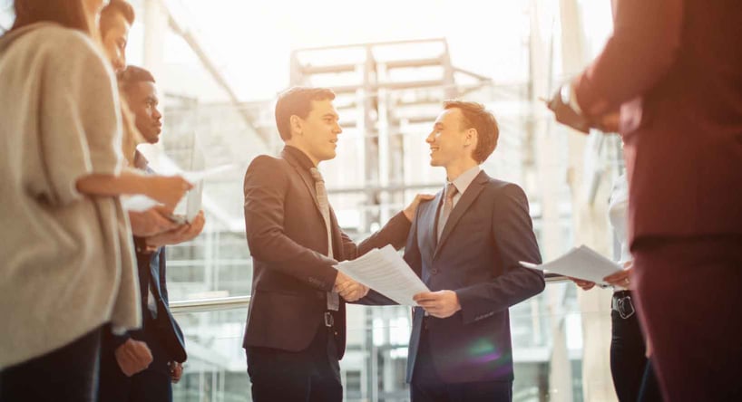 CEOs shaking hands during a mergers and acquisitions deal.